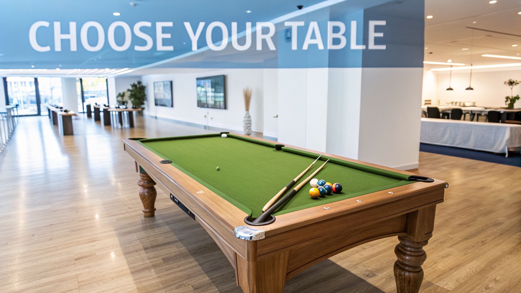 A spacious modern room features a wooden pool table with cues and colorful balls under a 'Choose Your Table' sign.
