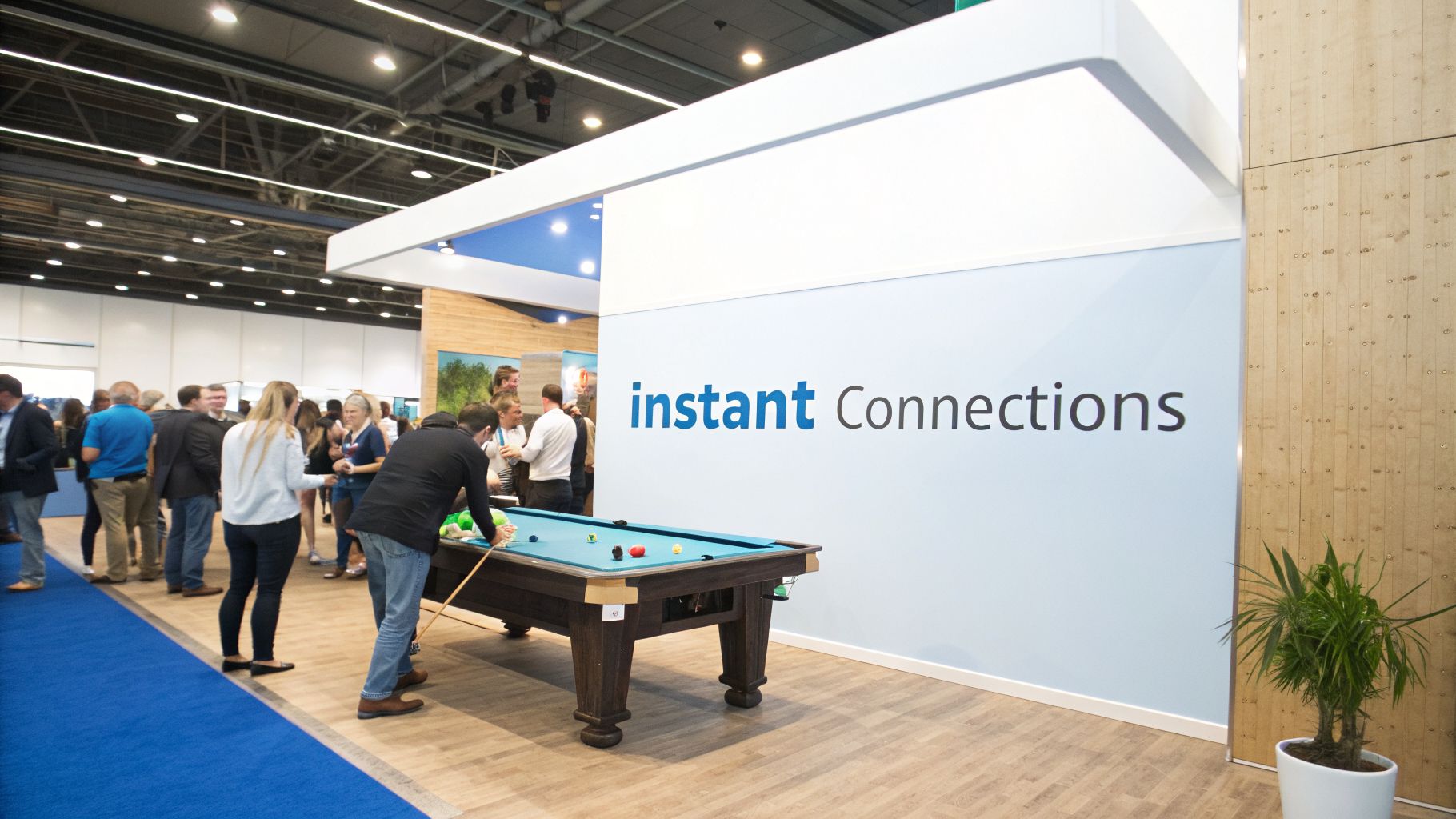 Attendees play pool and network at a vibrant trade show booth with 'instant Connections' branding.