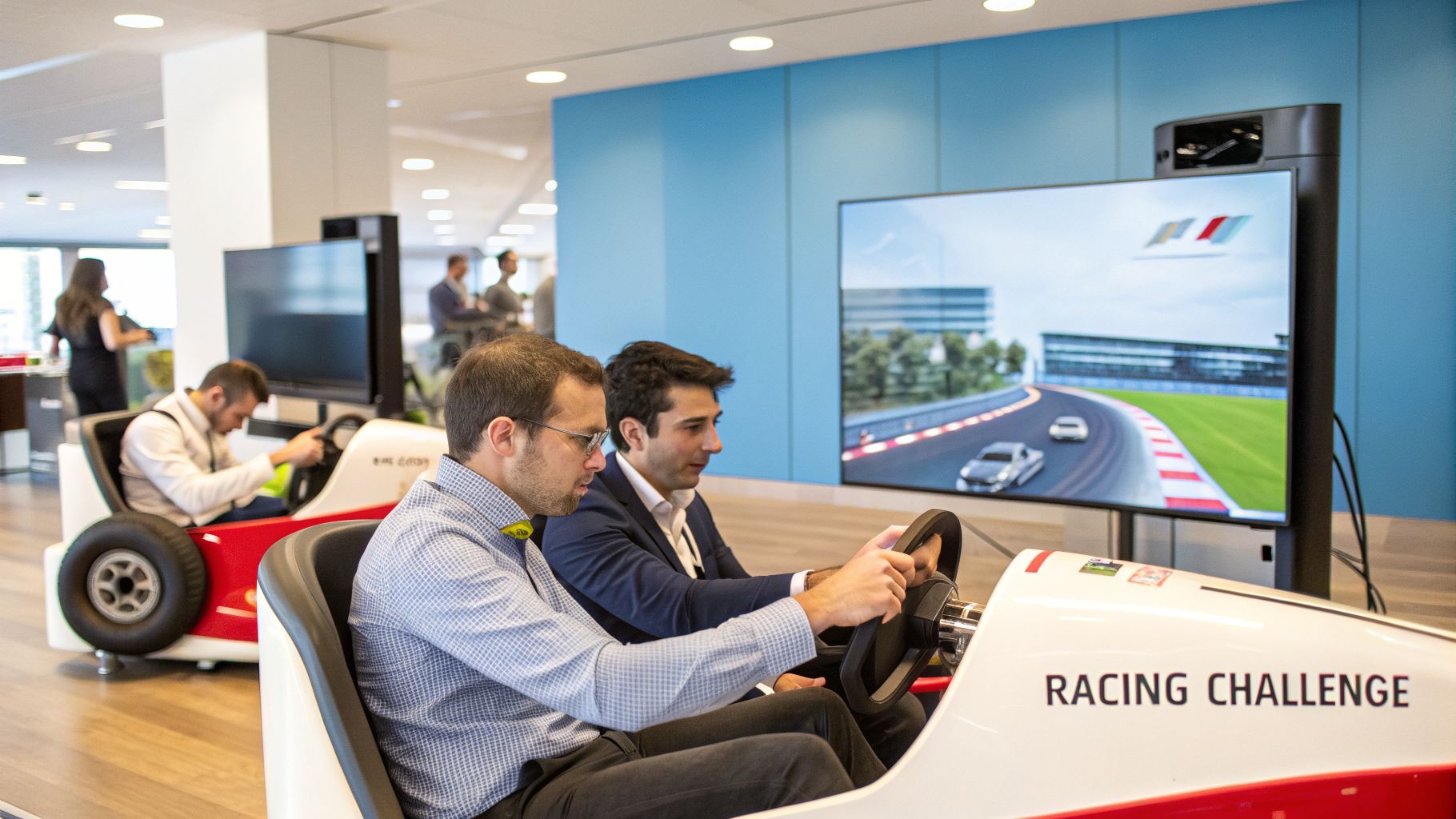 Two men intensely playing a racing simulator game, sitting in custom race car seats, with a large screen showing a virtual race track.
