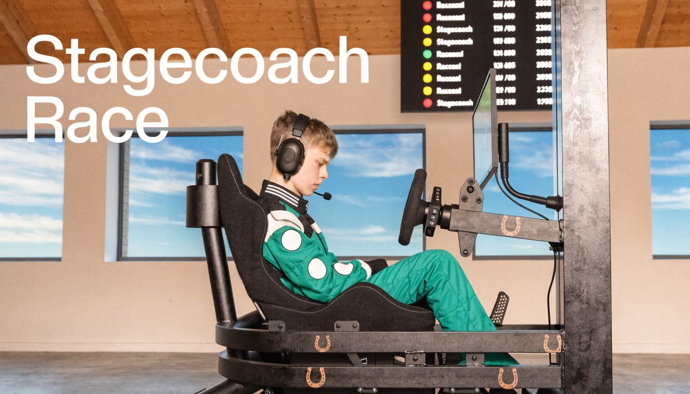 A young gamer wearing a racing suit and headset sits in a professional racing simulator setup.