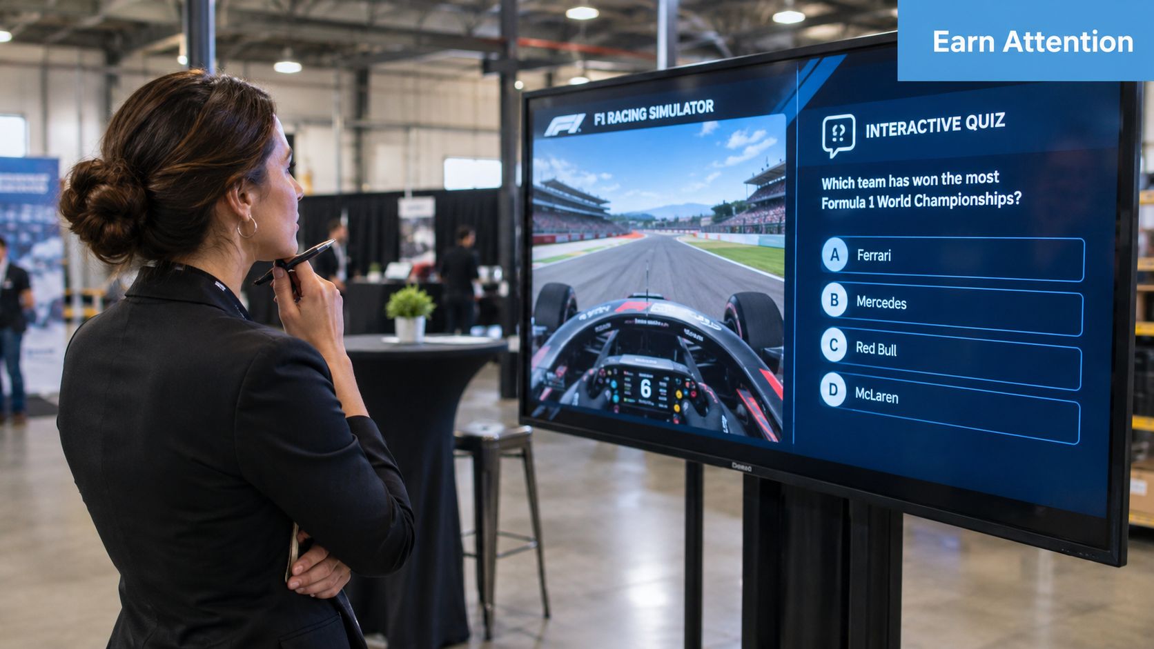 A professional woman looking at an interactive F1 racing simulator quiz screen during a brand activation event.