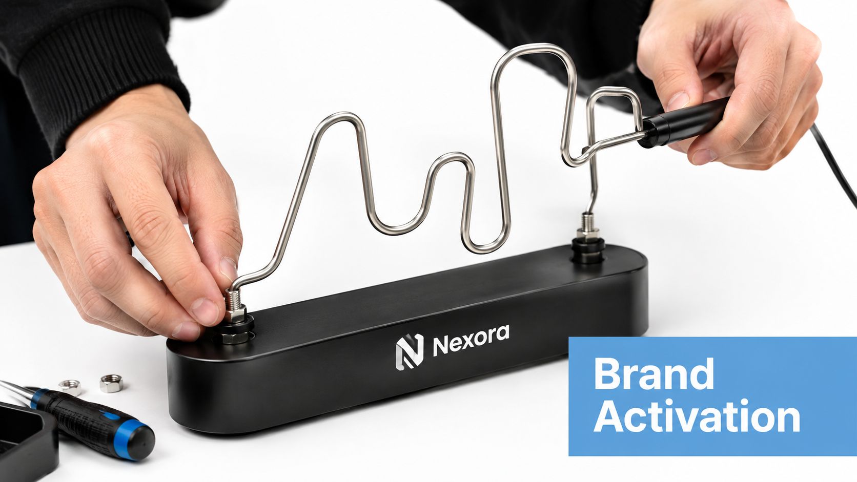 A person setting up a wire buzzer game with a metal loop and a black base.